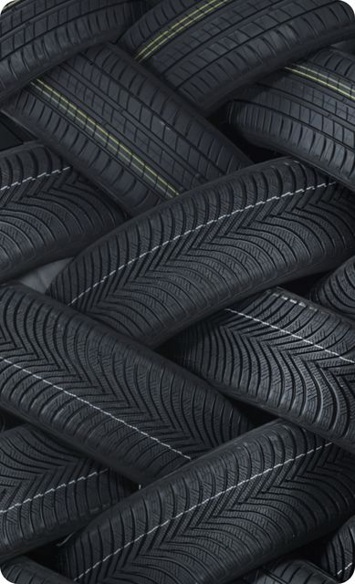 Das Foto zeigt eine Vielzahl von Reifen, die übereinander gestapelt sind.