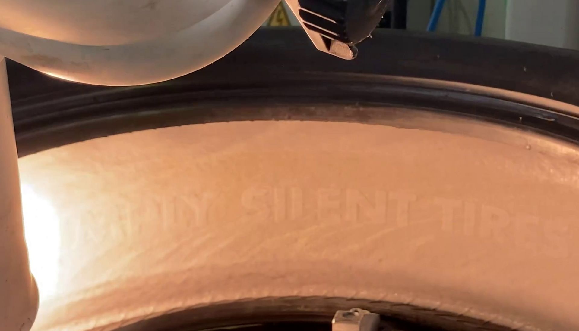 In einem Reifen befindet sich ein pinker Schaum mit der Aufschrift Simply Silent Tires. Ein Laser öffnet die geschlossene Oberfläche.