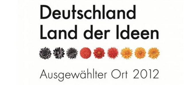 Logo vom Wettbewerb „365 Orte im Land der Ideen“. Darauf zusehen der Schriftzug: „Deutschland – Land der Ideen – Ausgewählter Ort 2012“