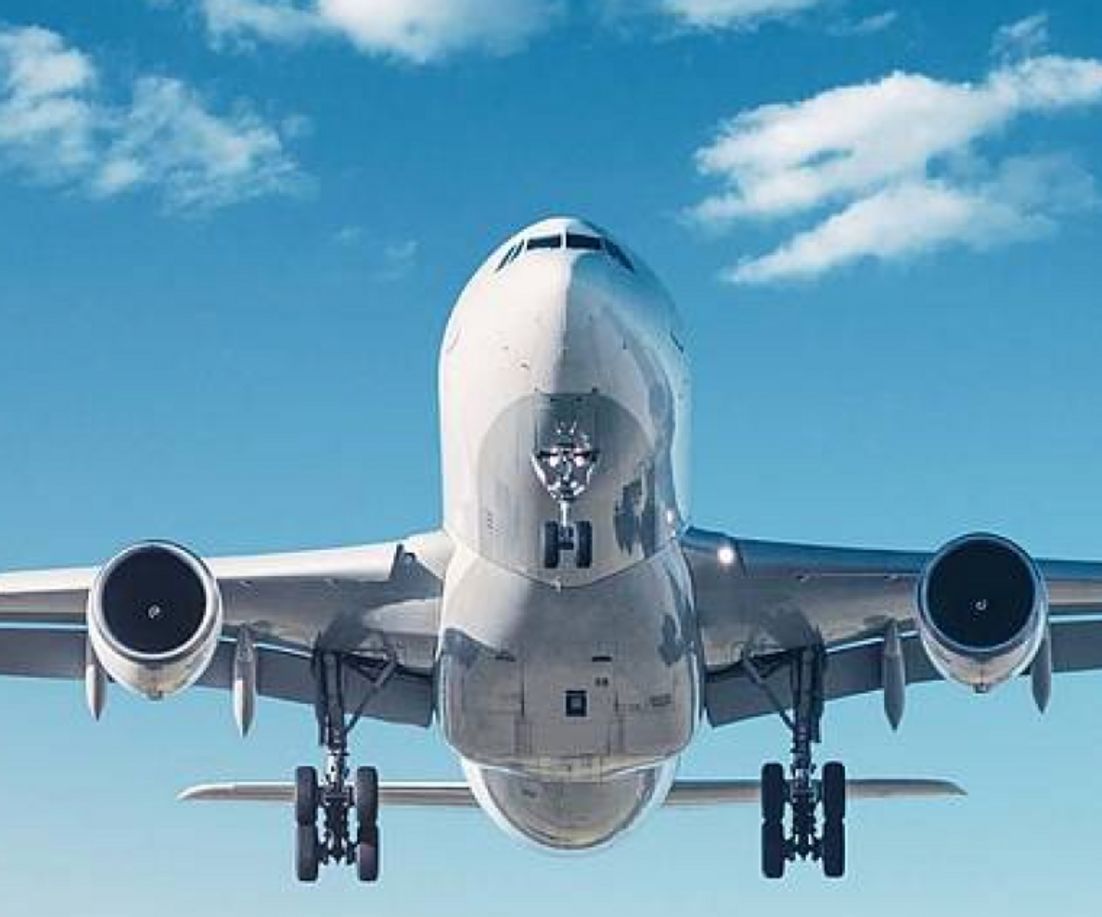 Foto eines Flugzeugs, das über ein Kornfeld fliegt. 