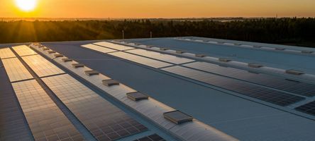 Photo of a factory roof with numerous thin-film photovoltaic modules.