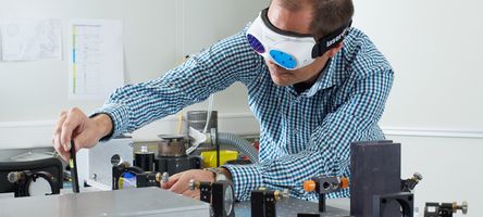 [Translate to German:] A 4JET technician fine-tuning a laser beam.