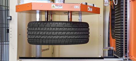 The gripper arm of the tire cleaning system transports the next tire into the machine for processing.