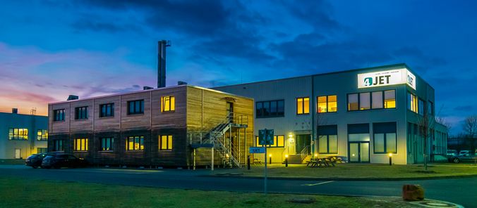 Die Außenfassade des ehemaligen Hauptgebäudes von 4JET am Abend.