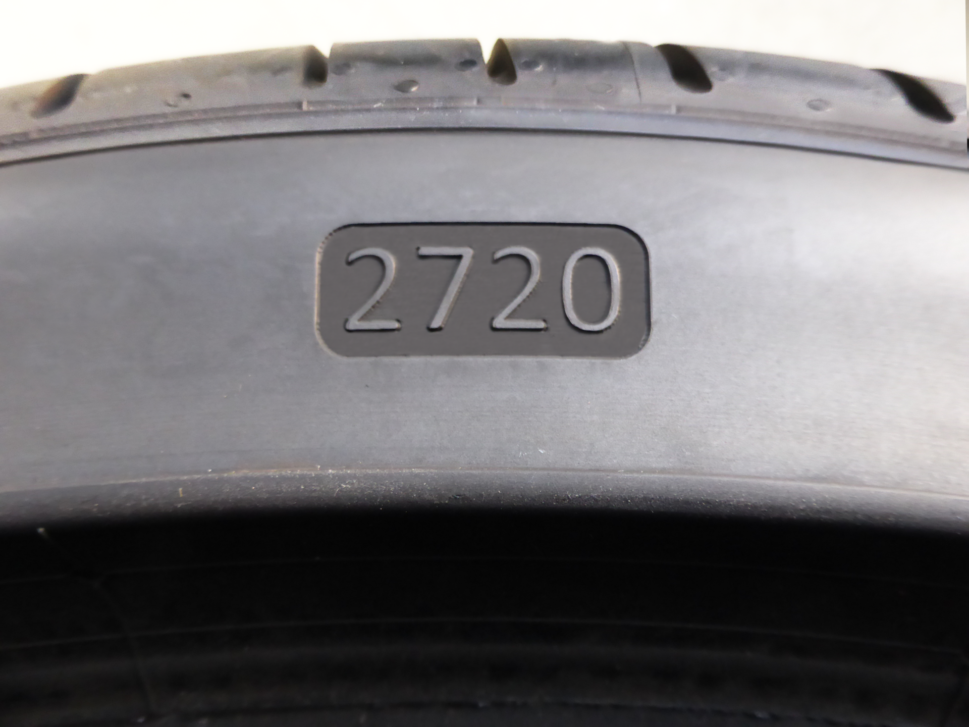 Nahaufnahme einer Reifenseitenwand mit lasergraviertem DOT-Datumscode, der den brasilianischen Inmetro-Vorschriften entspricht.