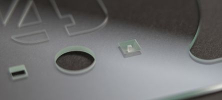 Auf dem Foto ist eine Glasstück mit Bohrungen unterschiedlicher Form und Durchmessern zu sehen.