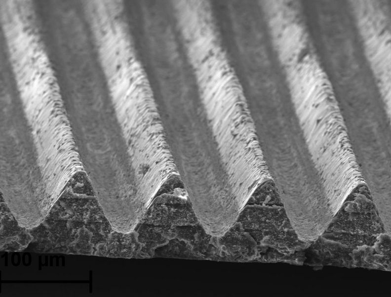 Eine Mikroskopaufnahme zeigt die sehr kleinen, regelmäßigen Strukturen auf dem Flugzeuglack.