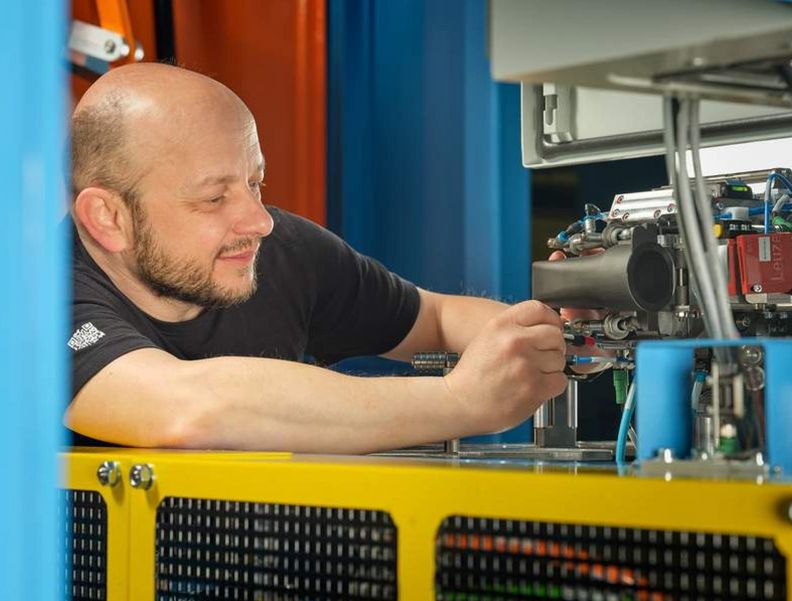 A 4JET mechatronics engineer maintains a laser machine.
