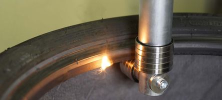 Foto eines Laserprozesskopfes, der an der Innenseite der Reifenwulst überschüssiges Gummi entfernt.