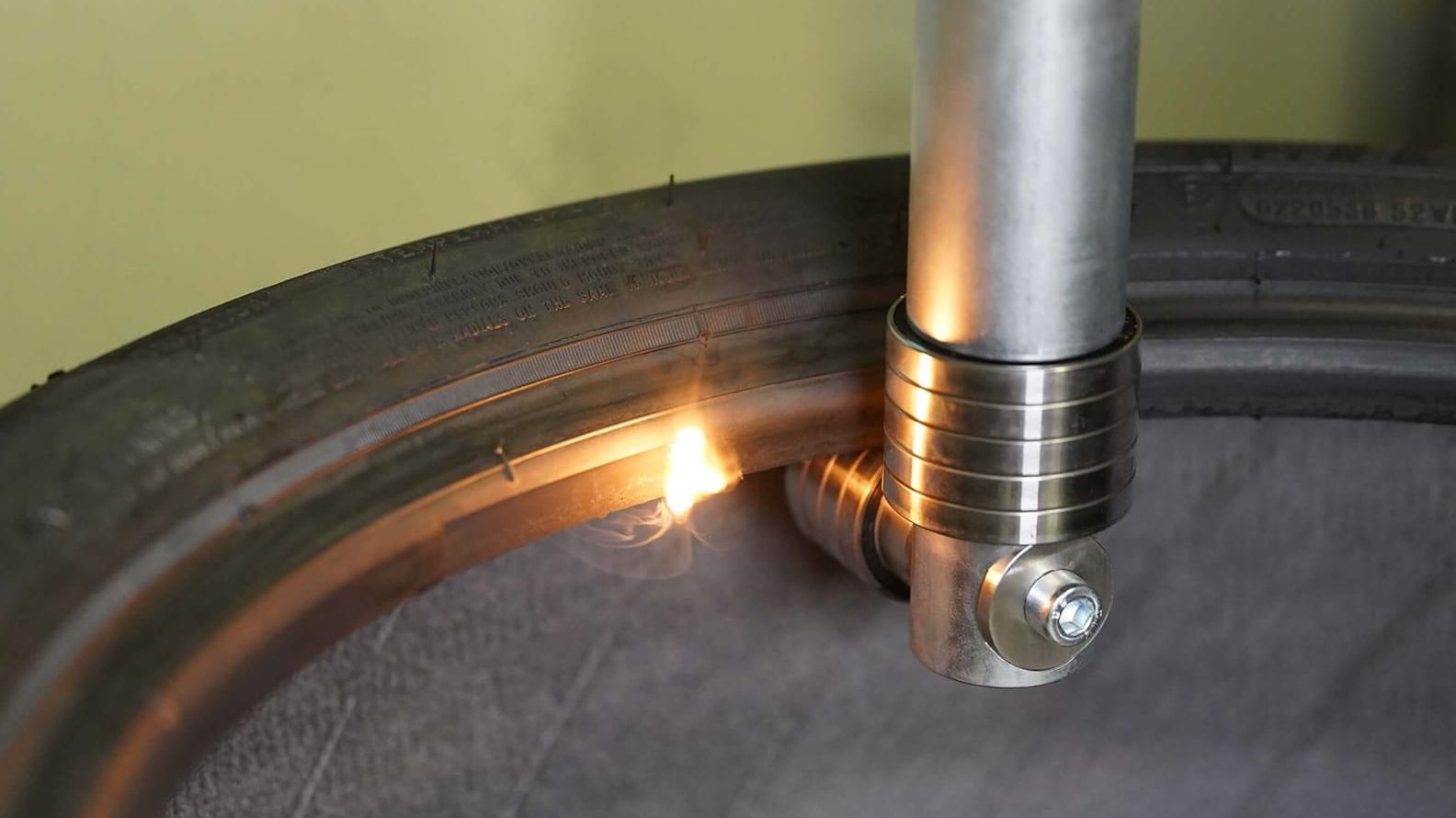 Photo of a laser process head removing excess rubber from the inside of the tire bead.