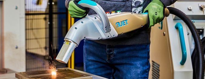 Ein 4JET Mitarbeiter reinigt ein Metallstück mit dem JETLASER.