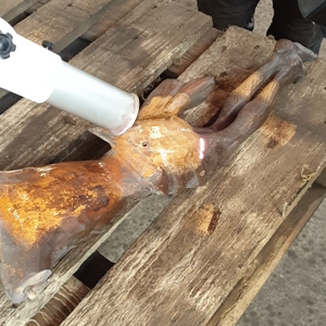 Paint stripping on wood for statue restoration