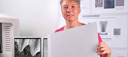 Eine 4JET Mitarbeiterin hält eine Probe mit der lasergravierten Haifischhaut in den Händen.