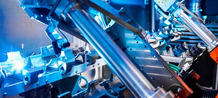 Close-up of two robotic arms, each with a laser process head, which are structuring components.