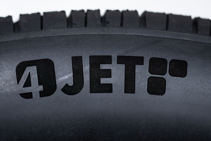 Nahaufnahme einer Lasergravur des 4JET Logos auf einer Reifenseitenwand.
