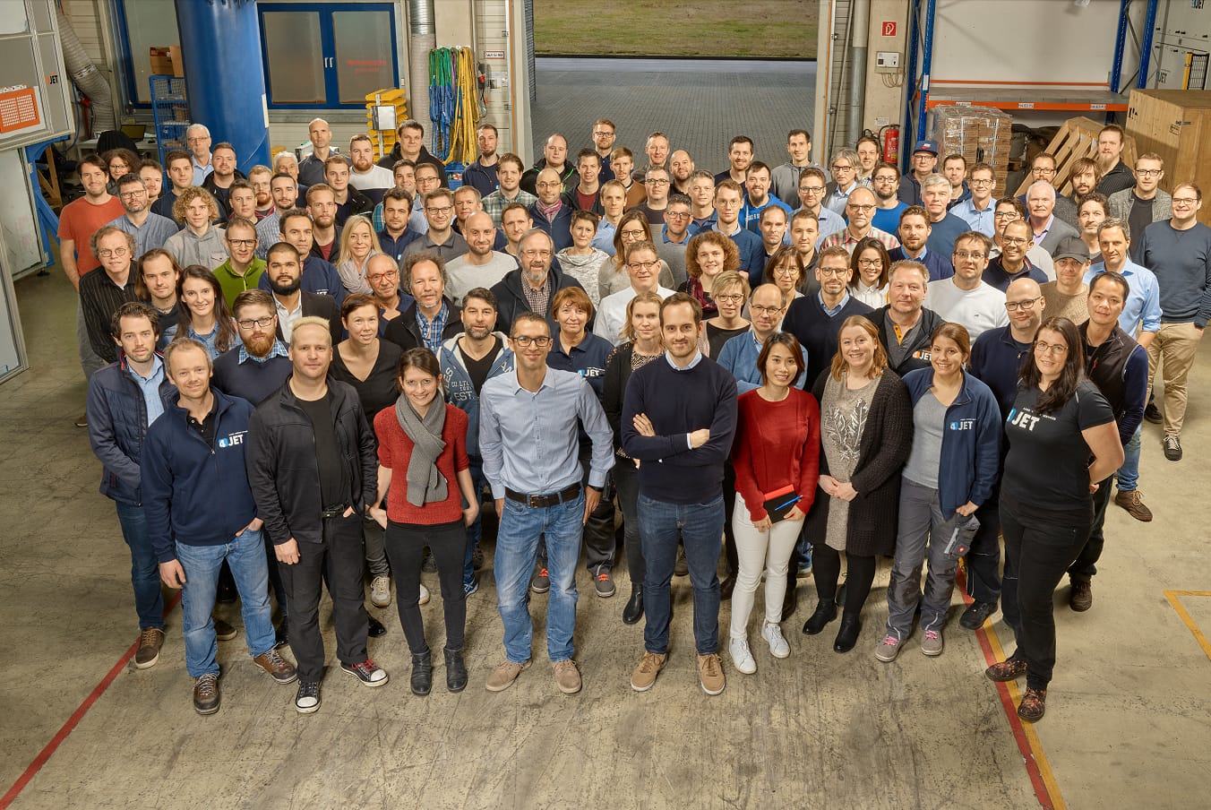 Großes Gruppenfoto von 4JET-Mitarbeitern in der Montagehalle.