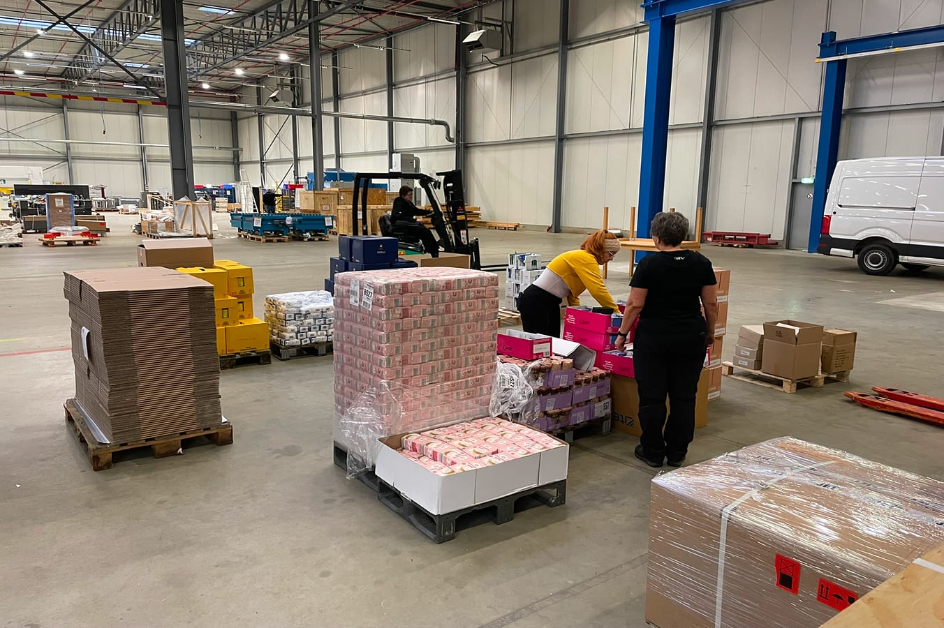 4JET-Mitarbeiter packen zusammen Spendenkartons.