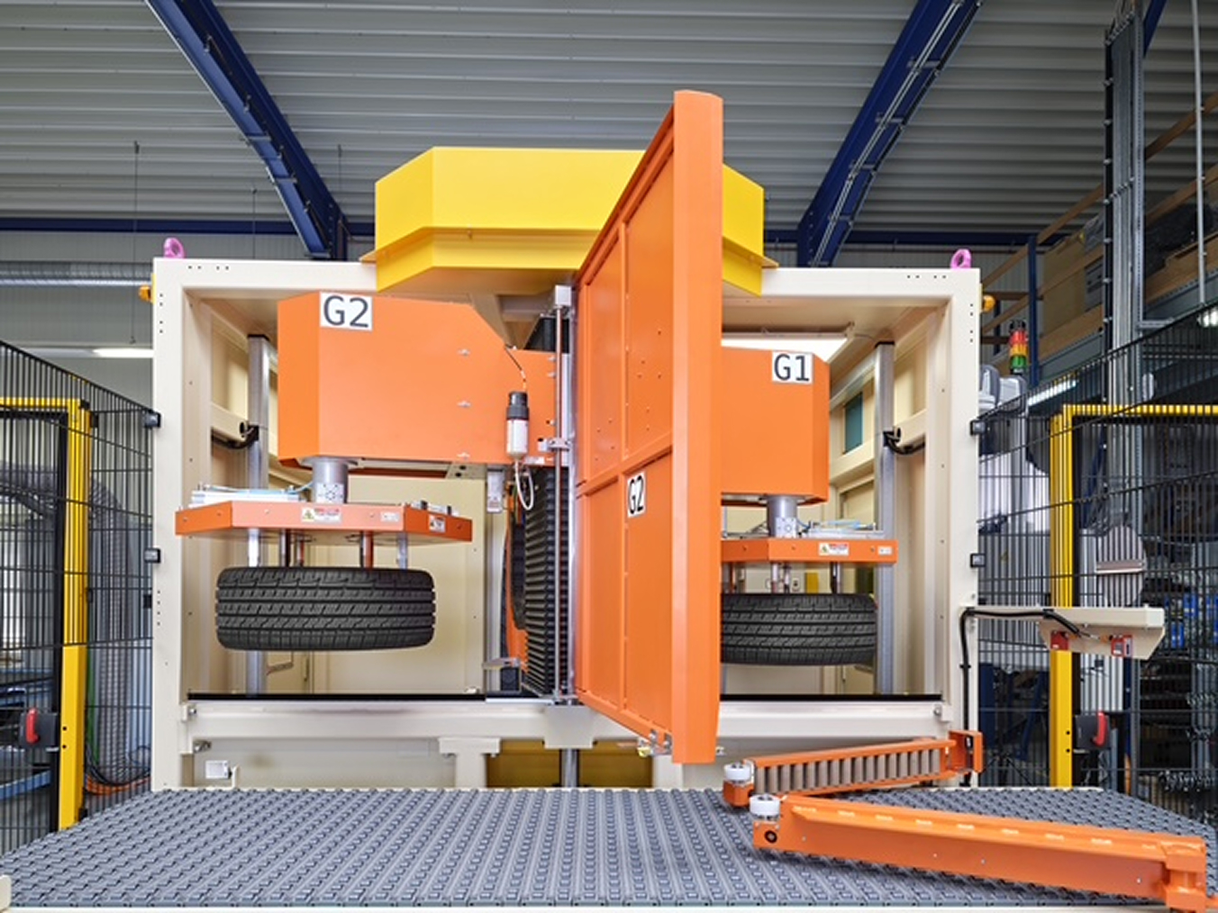 Nahaufnahme eines Lasersystems zur Reinigung von Reifen-Innerlinern mit Drehtür und zwei Greifern in einer Industrieumgebung