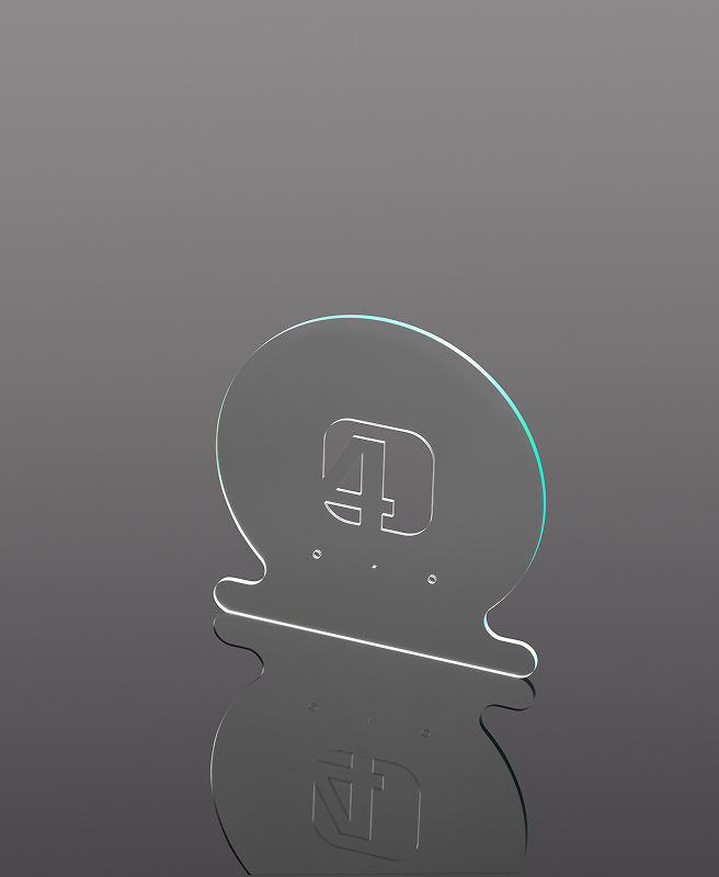 Das Foto zeigt eine Glasprobe mit geschwungenen Außenkonturen und feinen Innenausschnitten.