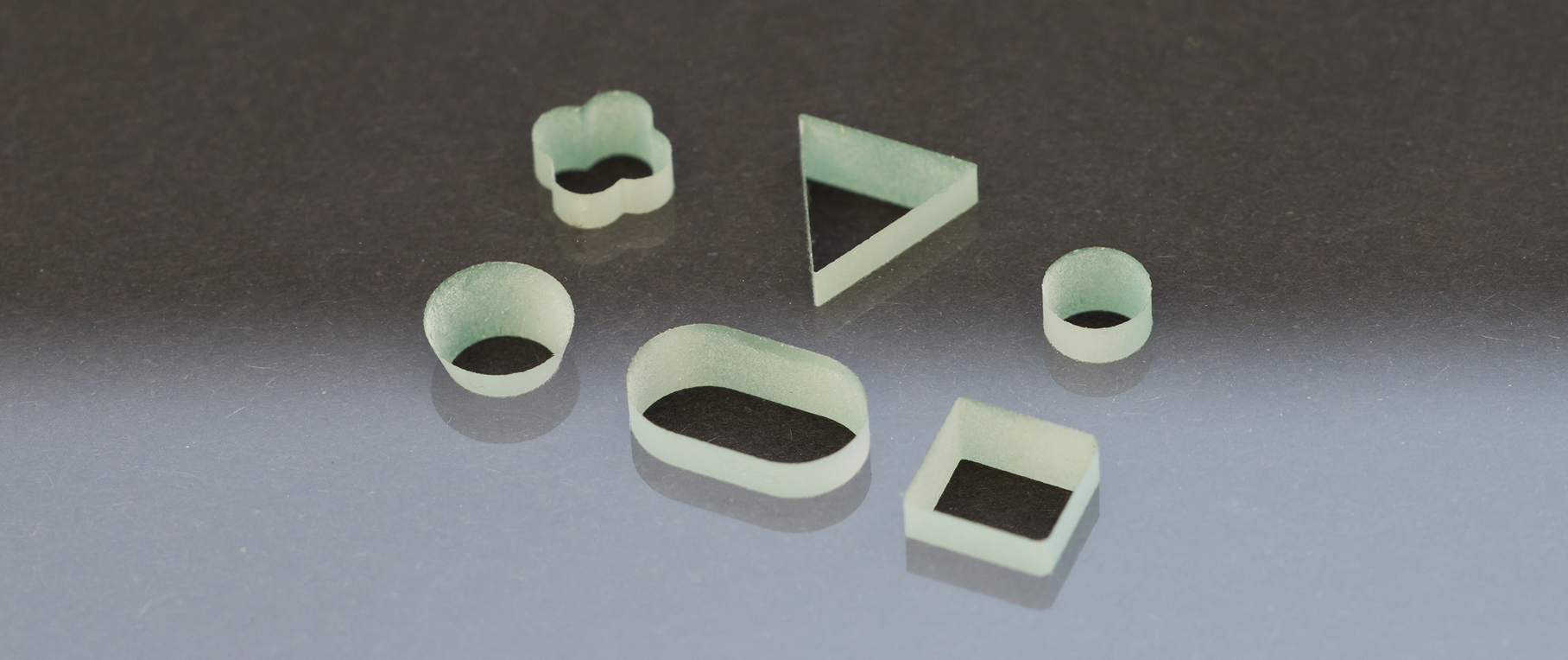 Nahaufnahme mehrerer Glasbohrlöcher mit unterschiedlichen Formen.