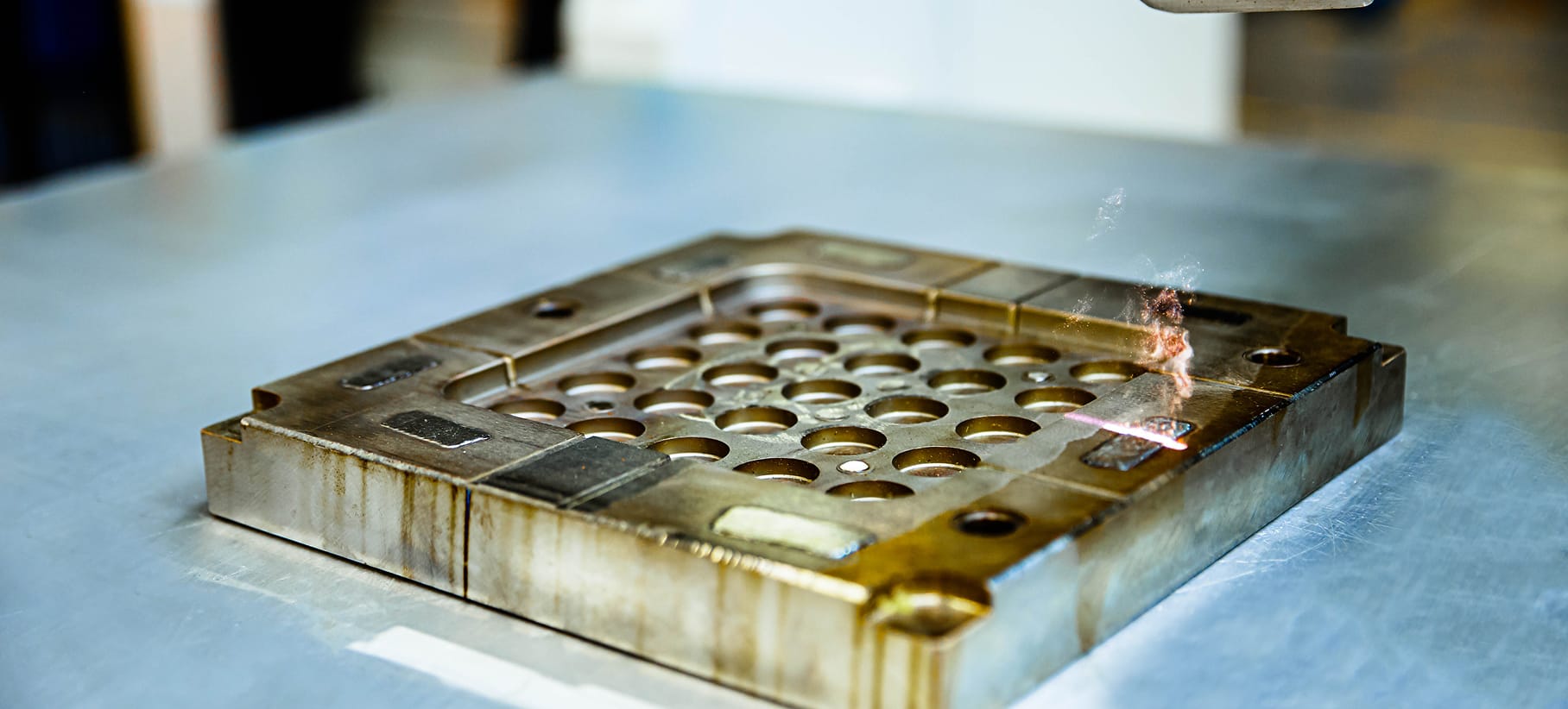 Nahaufnahme eines verunreinigten mechanischen Bauteils, das per Laser gereinigt wird.