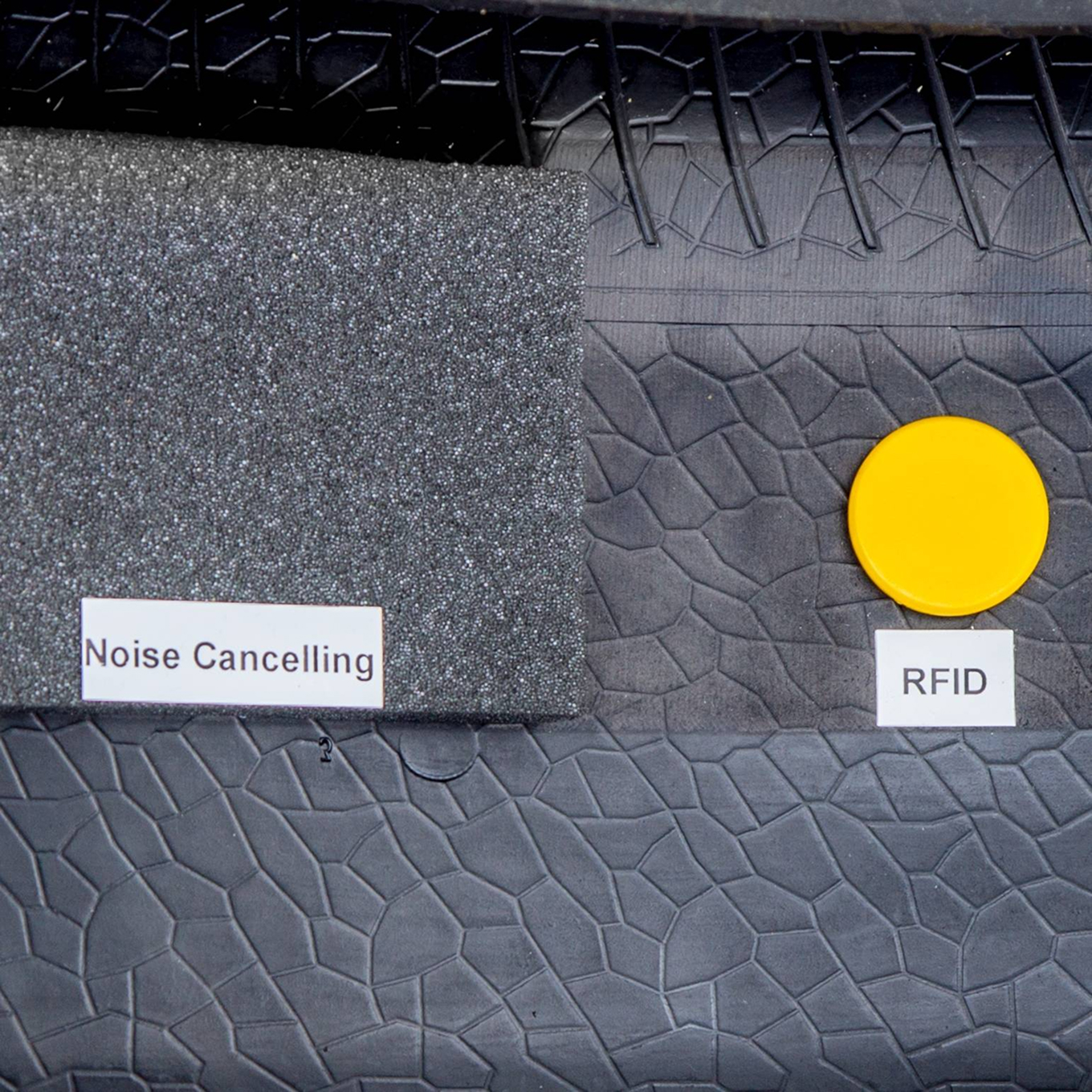 Nahaufnahme eines Reifenausschnitts mit nach dem Vulkanisieren eingebrachtem Dämmschaum und RFID-Funktransponder