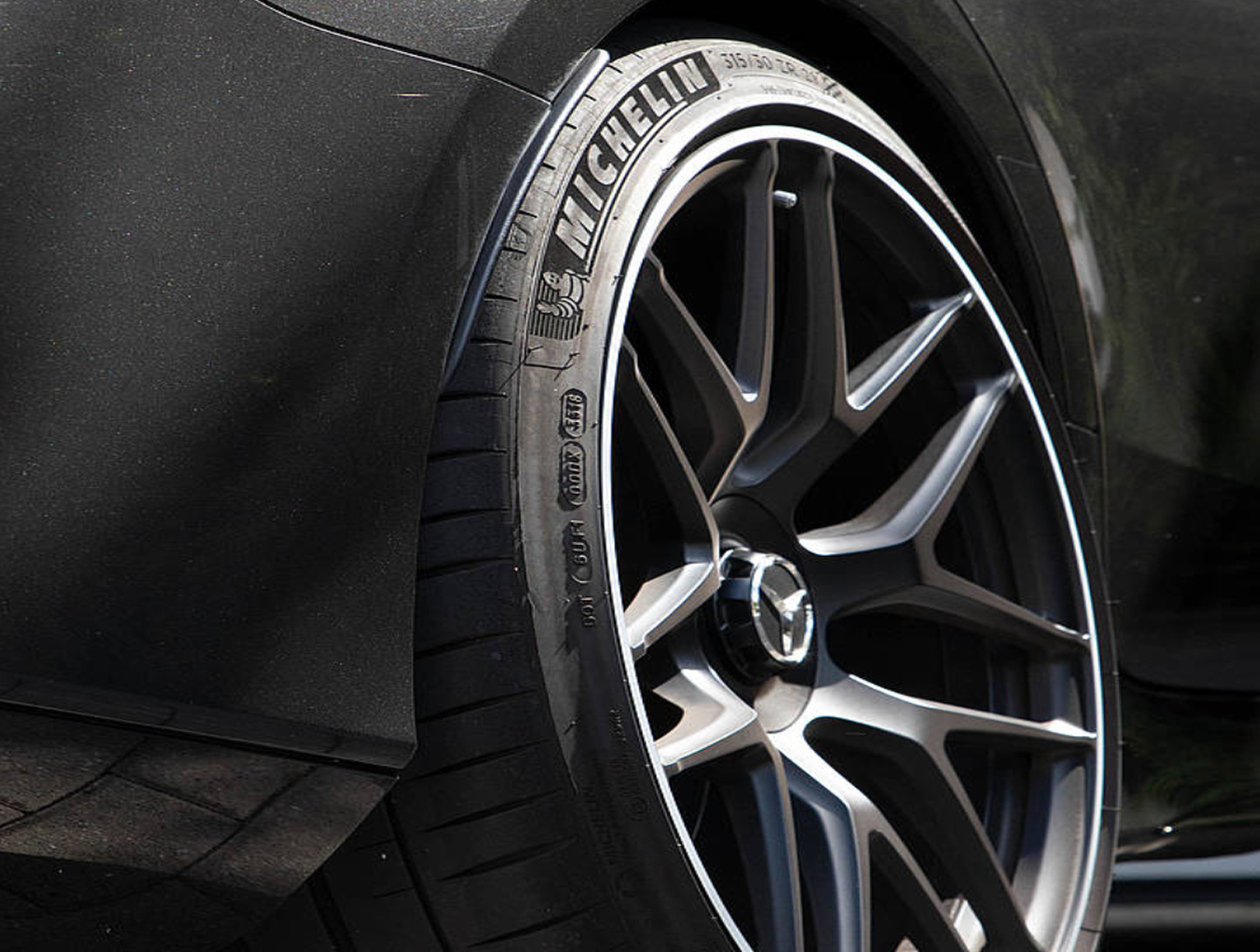 Bild eines Autorads. Der Markenname sowie Kennzeichnungen auf dem Reifen heben sich deutlich ab.