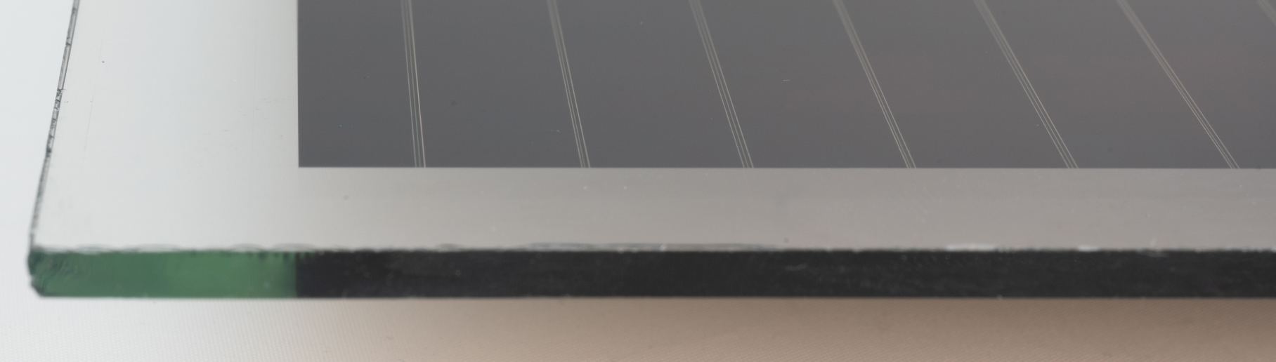 Ecke eines Photovoltaikpanels. Der Randbereich ist dabei von der Beschichtung befreit.