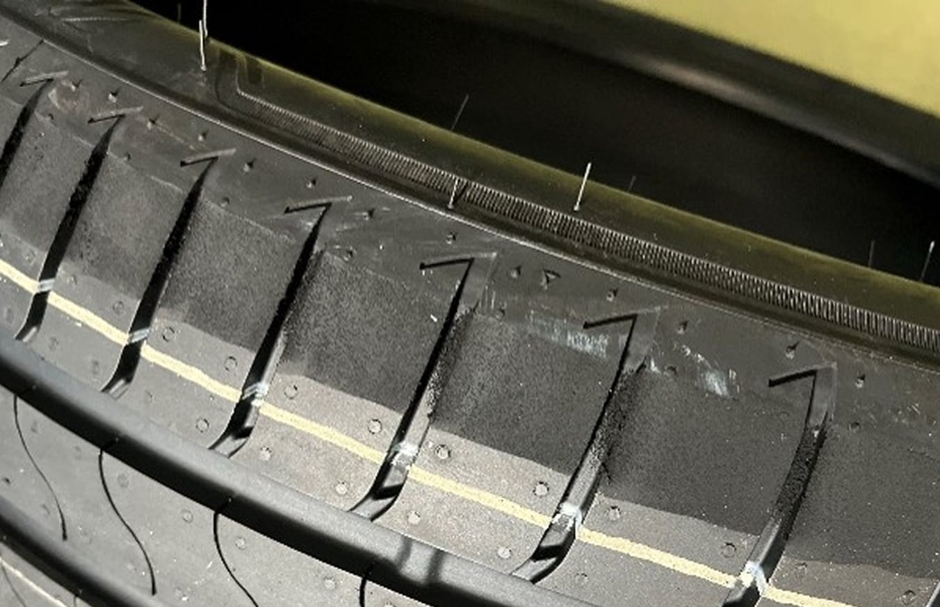 Das Bild zeigt einen Reifen, bei dem mangelnde Gleichförmigkeit durch mechanisches Schleifen auf der Außenseite korrigiert wurde. Der Reifen ist dadurch optisch beeinträchtigt.