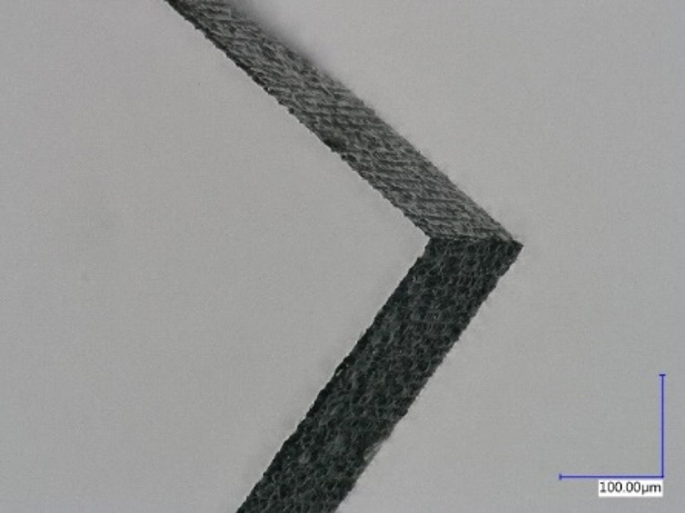 Mikroskopische Aufnahme eines nanoPerforierten Glaswafers nach dem Brechen. Vorher sind lediglich strukturierte Linien zu erkennen, danach eine klar geschnittene Kante.