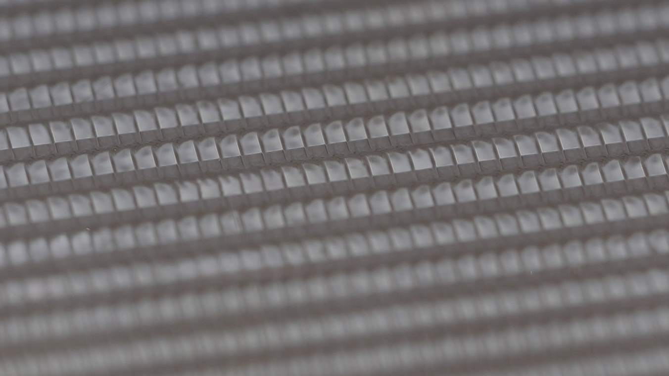 Detailansicht eines Glasbauteils, welches mit einem Laser vollflächig texturiert wurde. Die Pulse sind hier einzelnd erkennbar.