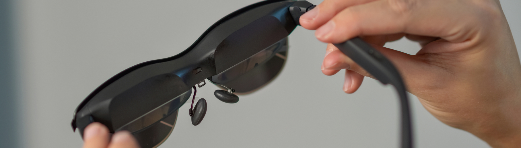 Foto einer AR-Brille, die von zwei Händen gehalten wird.