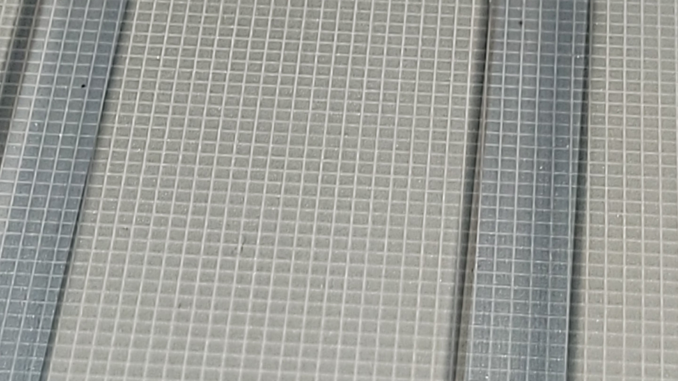 Top view of a glass substrate with a full-area grid-like structure. The grid appears brighter than the rest of the substrate.