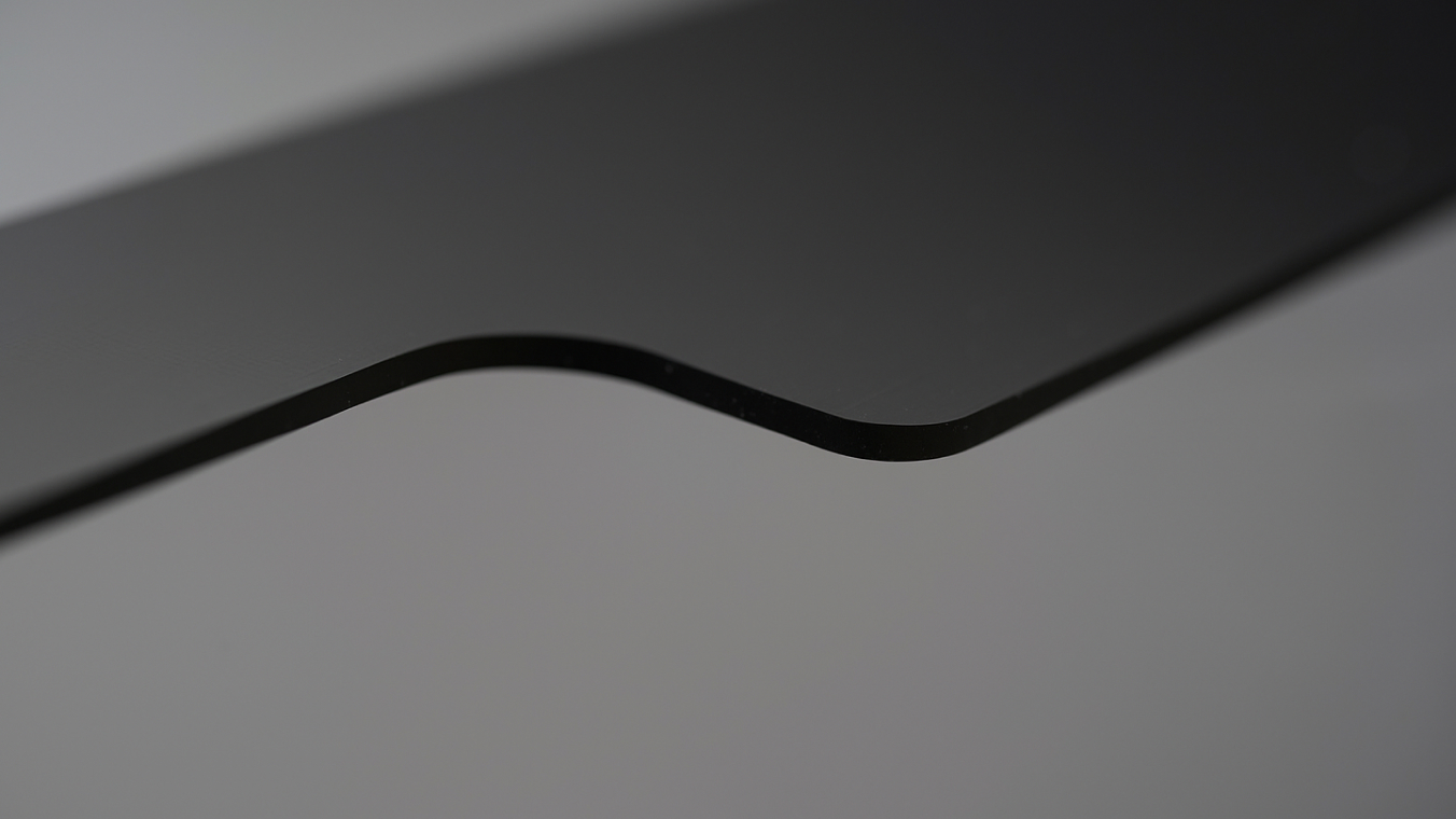 Macro image of a laser-cut glass edge. The glass has a black print.