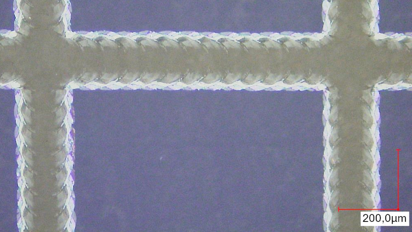 Microscope image of a grid-like ablation pattern. The individual overlapping spots are visible.