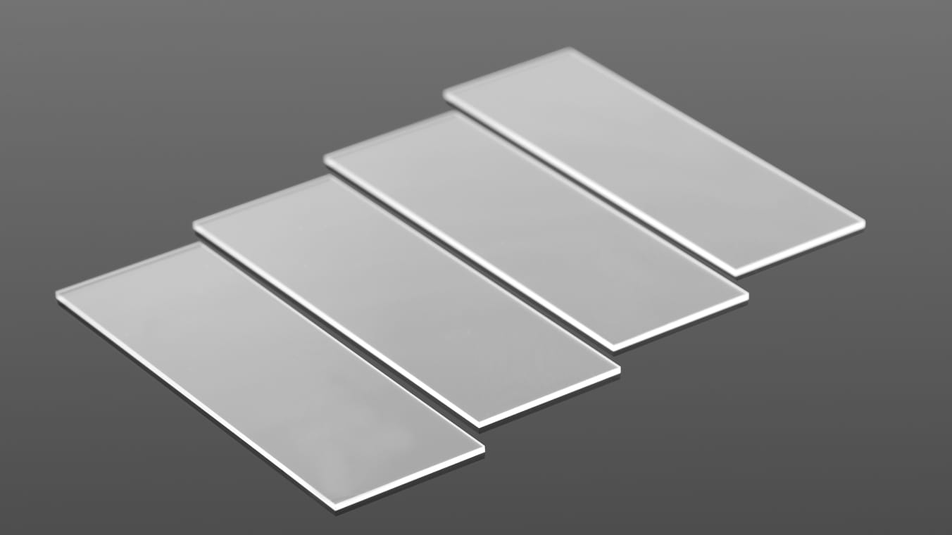 Aufnahme von vier identischen rechteckigen Glasbauteilen aus dünnem Glas.