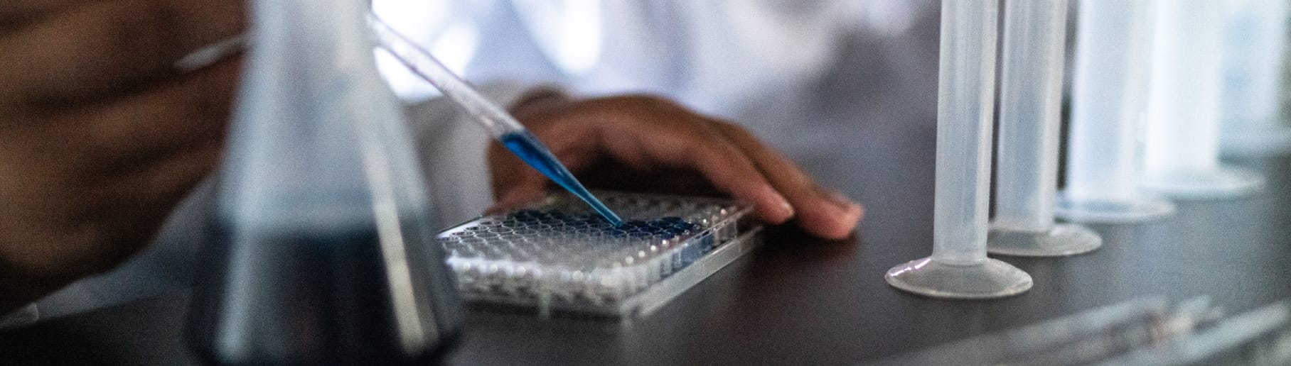 Close-up of a pipetting process with a glass pipette.