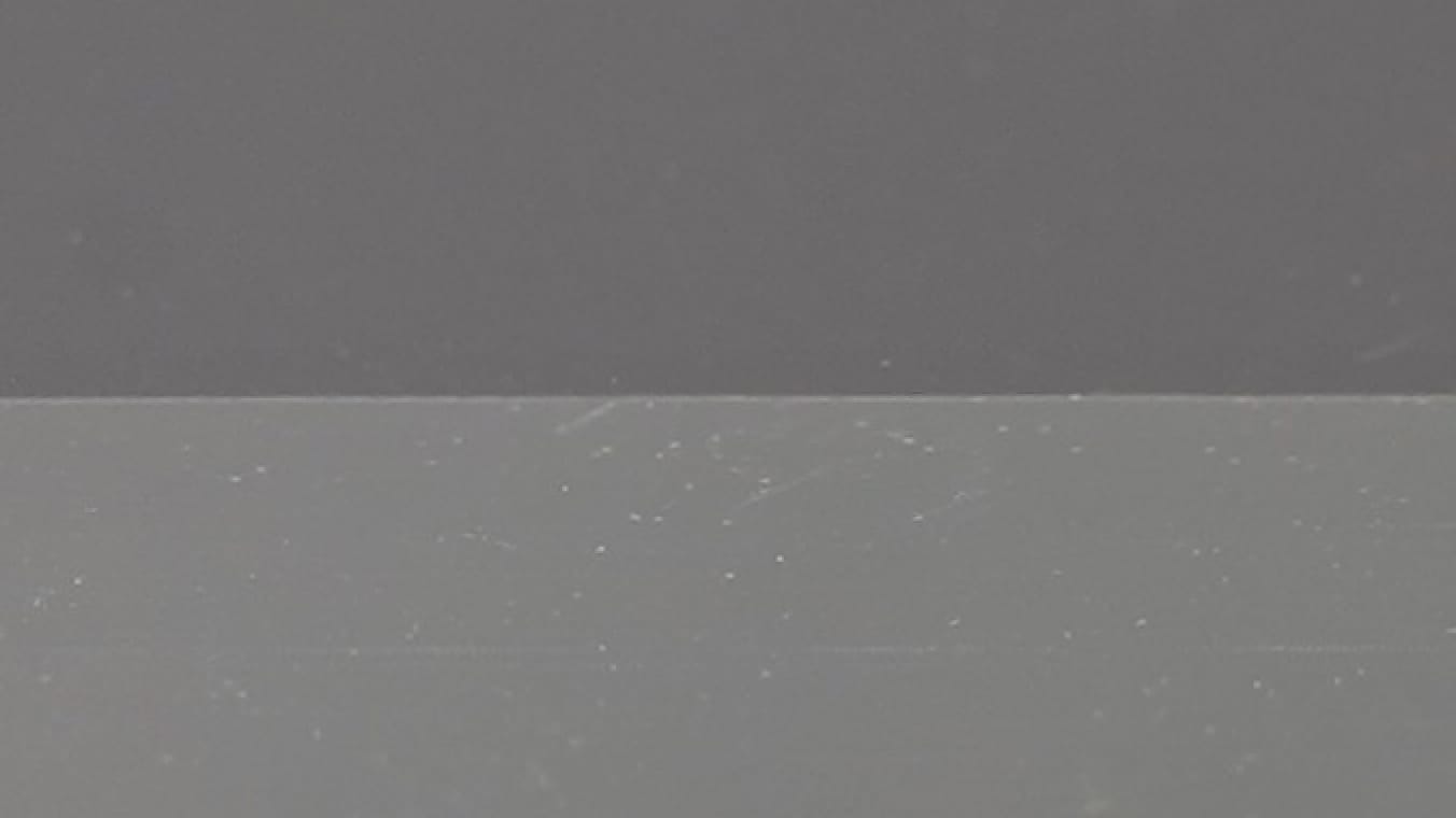 Nahaufnahme einer Glasscheibe mit zwei unterschiedlich hellen Bereichen. Die beiden Bereiche werden sauber in der Mitte sauber horizontal voneinander getrennt.