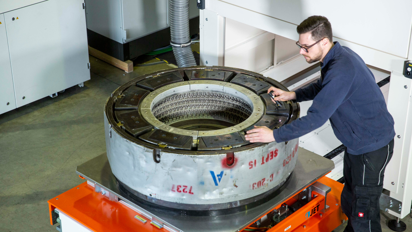 An employee inspects a cleaned tire mold.